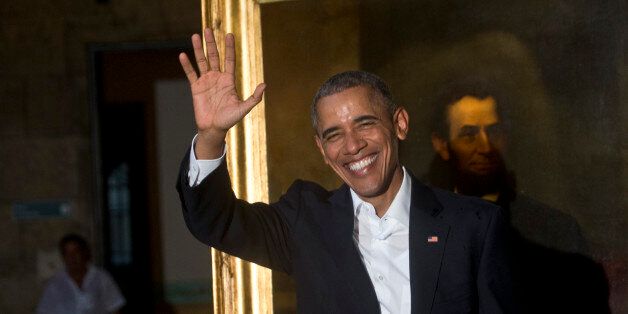 President Barack Obama waves to journalists next to a painting of President Abraham Lincoln at Havana's City Museum during a visit to Old Havana, Cuba, Sunday, March 20, 2016. Obama's trip is a crowning moment in his and Cuban President Raul Castro's ambitious effort to restore normal relations between their countries. (AP Photo/Ramon Espinosa)