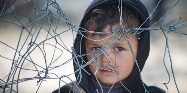 A boy stands in queue for food at a makeshift camp at the Greek-Macedonian border near the village of Idomeni on March 21, 20