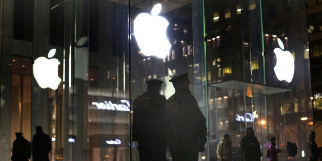 New York police officers stand outside the Apple Store on Fifth Avenue while monitoring a demonstration, Tuesday, Feb. 23, 2016, in New York. Protesters assembled in more than 30 cities around the world to lash out at the FBI for obtaining a court order that requires Apple to make it easier to unlock an encrypted iPhone used by a gunman in December's mass murders in California. (AP Photo/Julie Jacobson)