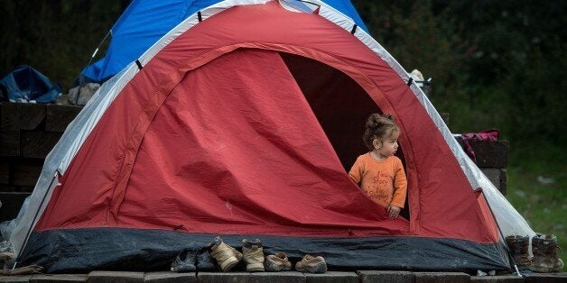 A girl stands inside a tent at a makeshift camp for migrants and refugees at the Greek-Macedonian border near the village of Idomeni on March 25, 2016.The UN human rights chief voiced alarm over an EU-Turkey deal to slow migrant arrivals to Europe, saying it had legal flaws and contradictions that could have global repercussions. / AFP / ANDREJ ISAKOVIC (Photo credit should read ANDREJ ISAKOVIC/AFP/Getty Images)