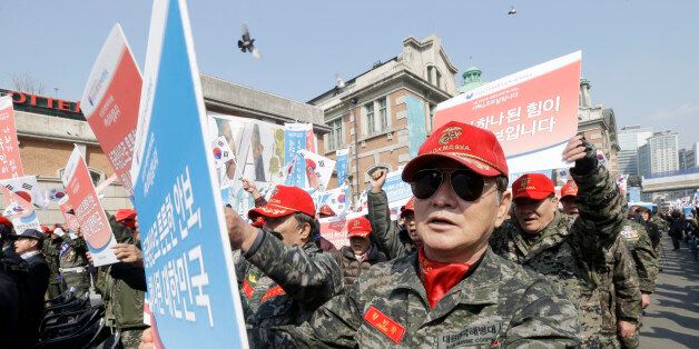 South Korean war veterans hold up their cards during a rally denouncing North Korea's recent threat in Seoul, South Korea, Friday, March 25, 2016. Day after day, North Korea claims worrying development in its weapons programs and ramps up fiery threats to attack rivals South Korea and the United States. The placards read: "No future for a country without awareness of national security and United Republic of Korea." (AP Photo/Ahn Young-joon)
