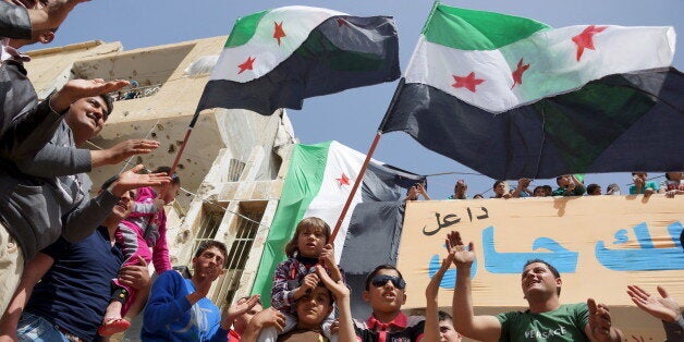 Protesters carry opposition flags and chant slogans during an anti-government protest in the rebel-held town of Dael, in Deraa Governorate, Syria March 25, 2016. REUTERS/Alaa Al-Faqir