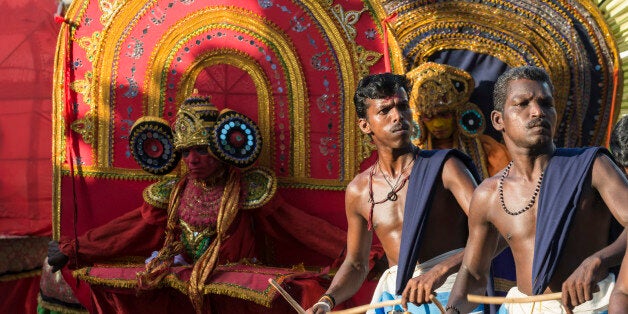 VARKALA, KERALA, INDIA - 2014/02/17: Two drummers are playing their instruments at a temple festival, theyyam dancers with yellow and red costumes behind them. (Photo by Frank Bienewald/LightRocket via Getty Images)