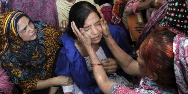 Family members comfort a woman mourns the death of a relative, who was killed in a blast outside a public park on Sunday, during funeral in Lahore, Pakistan, March 28, 2016. REUTERS/Mohsin Raza