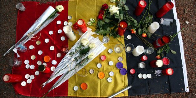 BRUSSELS, BELGIUM - MARCH 24: Flowers are left with a Belgian flag near Brussels airport on March 24, 2016 in Brussels, Belgium. Belgium is observing three days of national mourning after 31 people were killed in a twin suicide blast at Zaventem Airport and a further bomb attack at Maelbeek Metro Station. Two brothers are thought to have carried out the attacks and a manhunt is underway for a third suspect. The attacks came just days after a key suspect in the Paris attacks, Salah Abdeslam, was captured in Brussels. (Photo by Carl Court/Getty Images)