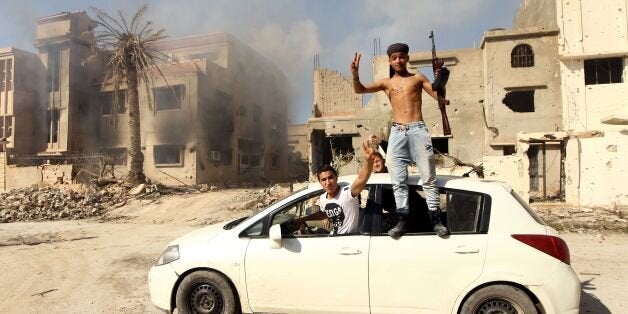 TOPSHOT - Fighters loyal to Libya's internationally recognised government celebrate as they come close to seizing the centre of the eastern coastal city on February 23, 2016, after a string of gains against Islamist militias including the Islamic State group.'We entered most of the sectors controlled by terrorist groups in Lithi' in central Benghazi, a source close to the pro-government troops told AFP. / AFP / ABDULLAH DOMA (Photo credit should read ABDULLAH DOMA/AFP/Getty Images)