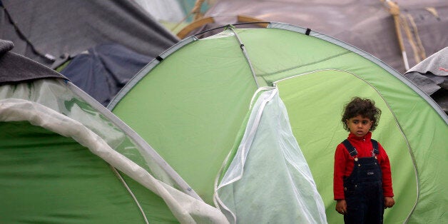 A girl stands in front of her tent in the makeshift refugee camp at the northern Greek border point of Idomeni, Greece, Saturday, April 2, 2016. Greece is pressing ahead with plans to start deporting migrants and refugees back to Turkey next week, despite mounting concern from the United Nations and human rights organizations that Syrians could be denied proper protection while some are allegedly even being forced back into their war-torn country. (AP Photo/Darko Vojinovic)