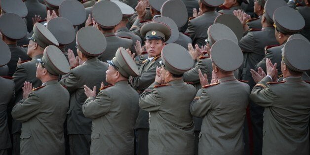 Soldiers applaud the arrival North Korean leader Kim Jong-Un during a mass military parade at Kim Il-Sung square in Pyongyang on October 10, 2015. North Korea was marking the 70th anniversary of its ruling Workers' Party. AFP PHOTO / Ed Jones (Photo credit should read ED JONES/AFP/Getty Images)