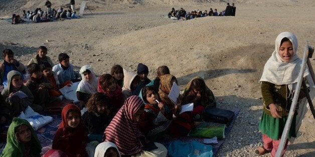 Afghan schoolchildren study at an open-air classroom in the Mohmand Dara district in eastern Nangarhar province on December 18, 2014. Afghanistan has had only rare moments of peace over the past 30 years, its education system undermined by the Soviet invasion of 1979, a civil war in the 1990s and six years of Taliban rule. AFP PHOTO / Noorullah SHIRZADA (Photo credit should read Noorullah Shirzada/AFP/Getty Images)