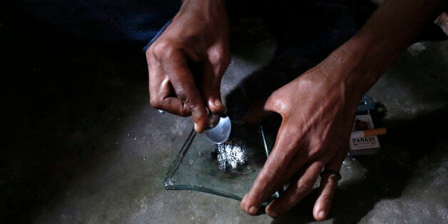 A heroin addict prepares heroin before using it in Lamu November 21, 2014. Picture taken November 21, 2014. To match KENYA-DRUGS/LAMU REUTERS/Goran Tomasevic (KENYA - Tags: DRUGS SOCIETY)