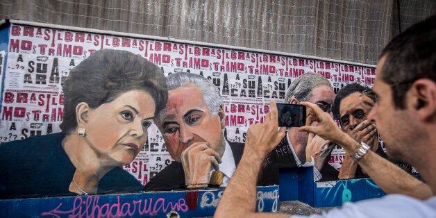 SAO PAULO, BRAZIL - APRIL 22: People pass a mural depicting president of Brazil Dilma Rousseff and Vice President Michel Temer at Paulista Avenue on April 22, 2016 in Sao Paulo, Brazil. (Photo by Cris Faga/LatinContent/Getty Images)