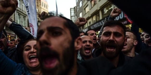 Protesters shout slogans on Istiklal Avenue in Istanbul on April 27, 2016, during a protest against a call for the country to adopt a religious constitution.Turkey's Prime Minister Ahmet Davutoglu vowed on April 27 that Turkey's draft constitution would guarantee secularism, after calls for a religious charter sparked controversy in the predominantly Muslim country. The call led to protests in major cities where police fired tear gas and rubber bullets to disperse demonstrators in Ankara and Istanbul. The separation of religion from state affairs is one of the fault lines in Turkish society. The founder of modern Turkey, Mustafa Kemal Ataturk, based the post-Ottoman republic on a strict separation between religion and state. / AFP / BULENT KILIC (Photo credit should read BULENT KILIC/AFP/Getty Images)