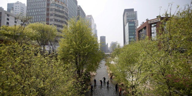 Workers remove dead leaves from the bed of Cheonggye stream in central Seoul, South Korea, April 14, 2016. REUTERS/Kim Hong-Ji