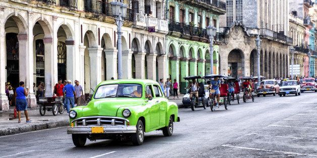 Street scene with vintage car and worn out buildings in Havana, Cuba.