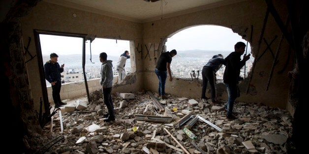 Palestinians inspect the damaged house of Zaid Amer, after it was demolished by the Israeli army, in the West Bank city of Na