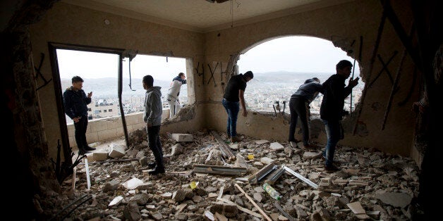 Palestinians inspect the damaged house of Zaid Amer, after it was demolished by the Israeli army, in the West Bank city of Nablus, Tuesday, May 3, 2016. The Israeli army demolished the house of Amer, an arrested member of a Hamas cell who carried out an attack and shot dead a U.S. couple, residents of the West Bank Israeli settlement of Neria, while driving home last October, the army said. (AP Photo/Majdi Mohammed)