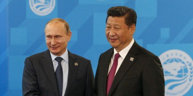 Russia's President Vladimir Putin (L) shakes hands with Chinese President Xi Jinping during the Shanghai Cooperation Organization (SCO) summit in Ufa, Russia, July 10, 2015. REUTERS/Sergei Karpukhin