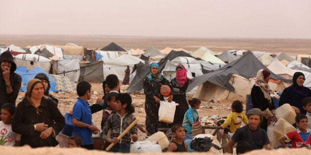 Syrian refugees await approval to enter Jordan at the Hadalat reception area on the Syrian-Jordanian border, about 320 kilometers (200 miles) northeast of the capital of Amman, Wednesday, May 4, 2016. The commander of Jordan's Border Guard Forces says the number of Syrian refugees amassed in remote desert areas on the Jordanian border and waiting to enter has risen to a new high of 59,000. (AP Photo/Raad Adayleh)