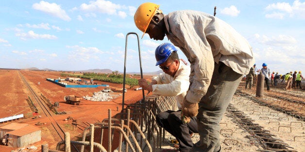 A Chinese engineer and a local construction worker work on a section of the Mombasa-Nairobi standard gauge railway (SGR) in Emali, Kenya October 10, 2015. The China Road and Bridge Corporation (CRBC) tasked with the construction work at a cost of 3.8 billion U.S. dollars is due for completion in mid-2017. REUTERS/Noor Khamis 