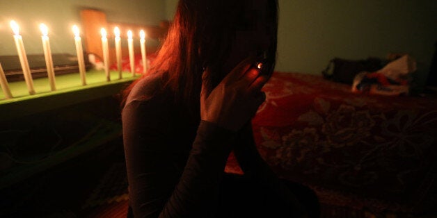 A Syrian sex trafficking victim smokes a cigarette at her safehouse at an undisclosed location in Lebanon on April 13, 2016, after she fled a brothel in Lebanon where she was being held captive. Lebanese security forces busted a sex trafficking ring involving 75 Syrian women trafficked to Lebanon from their country and forced into prostitution. / AFP / STRINGER (Photo credit should read STRINGER/AFP/Getty Images)