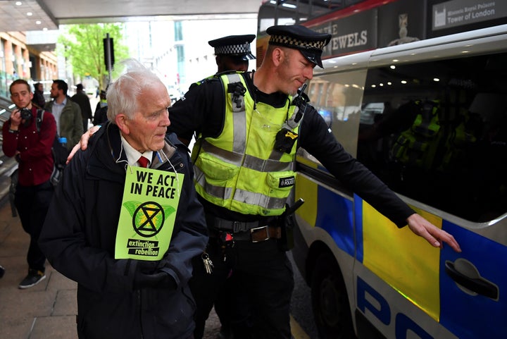 Kingston is led to a police car after being taken down from the top of a DLR train