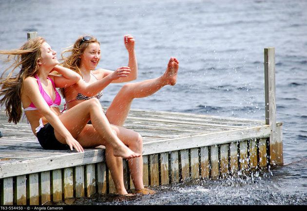 sisters 13 and 18 kicking up water while sitting on dock at