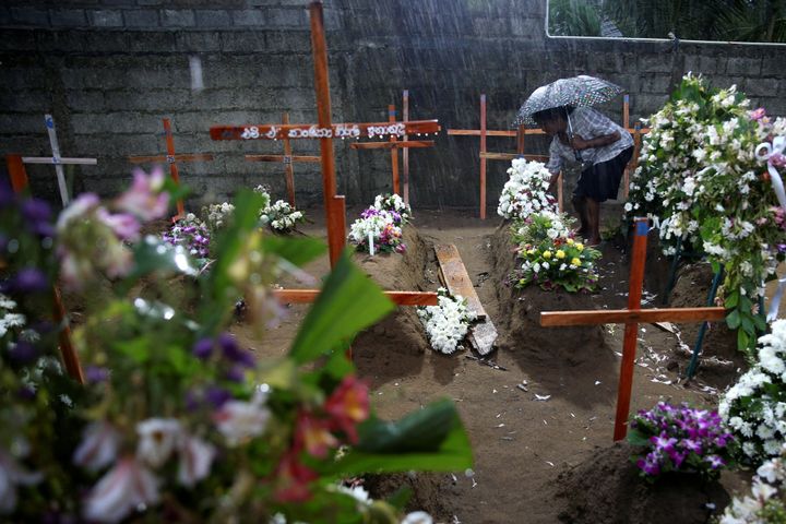 A woman comes to the site of a mass burial to pay her respects to the victims of a string of suicide bomb attacks on churches