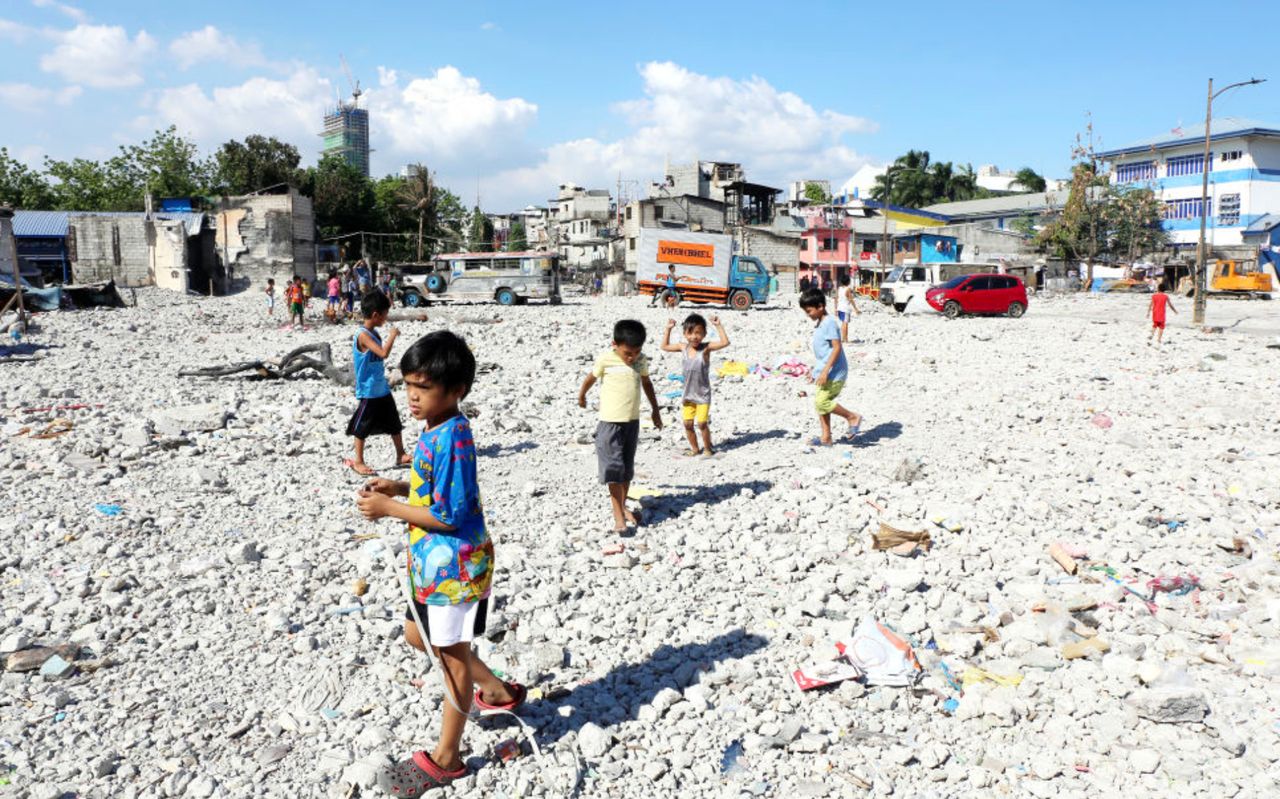 Children play where a fire recently destroyed a block of makeshift homes in a low-income area of Manila.