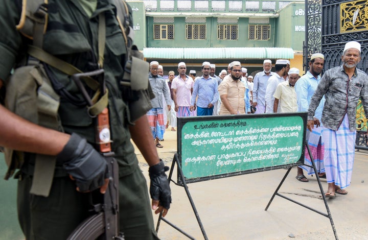 Sri Lankan security personnel stand guard outside Mohideen Meththai Grand Jumma Mosque during the Friday noon prayer in Katta