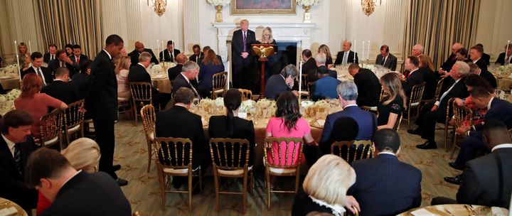President Donald Trump bows his head as his spiritual adviser Paula White prays during an Aug. 27, 2018, dinner for evangelical leaders at the White House.
