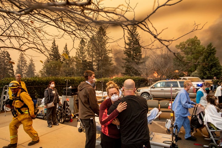 A nurse hugs a rescue worker during the Camp Fire last fall.&nbsp;