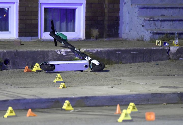  A scooter lies among evidence markers near the scene where authorities say eight people were shot, at least one fatally, Sunday, April 28, 2019, in Baltimore. (AP Photo/Steve Ruark)