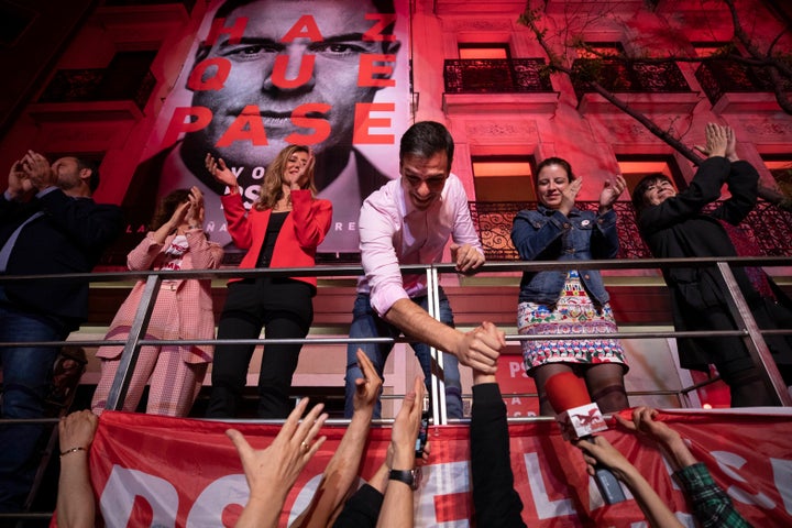 Socialist Party leader Pedro Sanchez shakes hands with supporters outside the party headquarters following the general electi