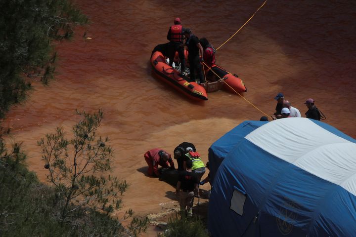 Police forensics officers retrieving a body in a suitcase from Kokkinopezoula lake, also known as "red lake", near the village of Mitsero, Cyprus