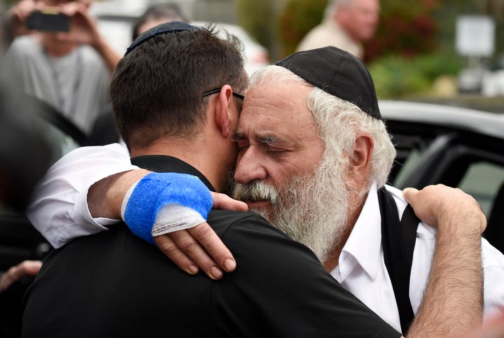 Rabbi Yisroel Goldstein (right) is hugged as he leaves a news conference at the Chabad of Poway synagogue on Sunday.