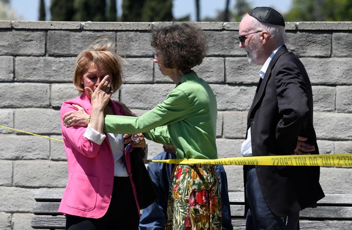Synagogue members console one another outside of the Chabad of Poway Synagogue on Saturday after a gunman opened fire, killing one person and wounding three others.