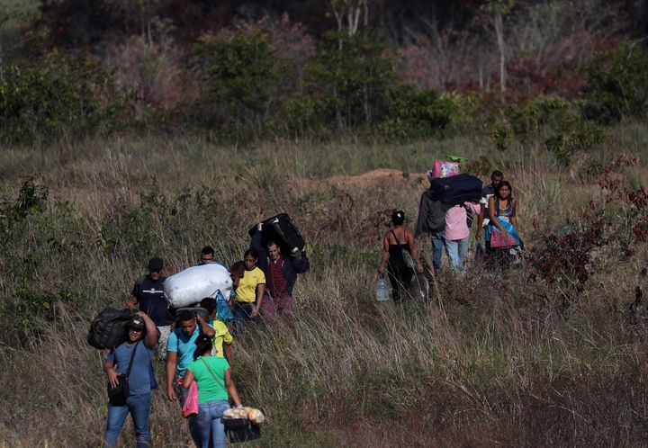 People cross through a field at the Brazil-Venezuela border in Pacaraima, Brazil, in February. More than 30,700 Venezuelans have migrated to Brazil since last August.