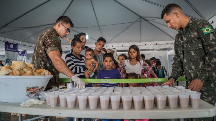 Venezuelan families wait for food and drink inside a refugee reception center in Pacaraima, Brazil, in early April.