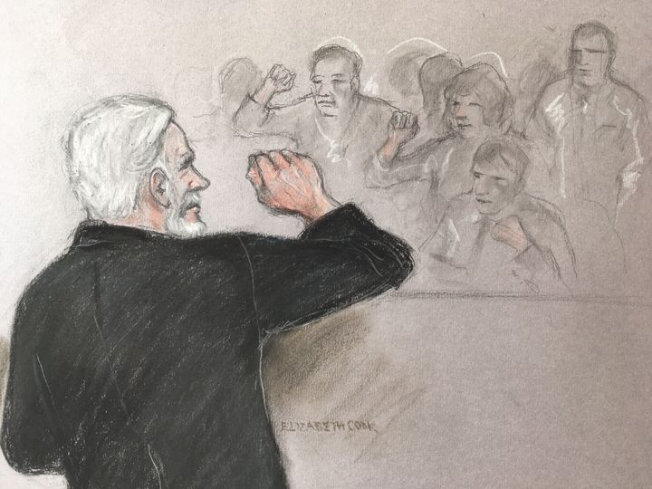 Court artist sketch by Elizabeth Cook of Julian Assange saluting his supporters as he appears before Southwark Crown Court in London for breaching his bail.