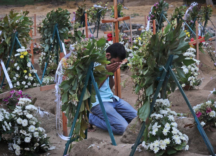 A Sri Lankan relative of a victim of Easter Sunday bomb blasts pays tribute at the burial site.