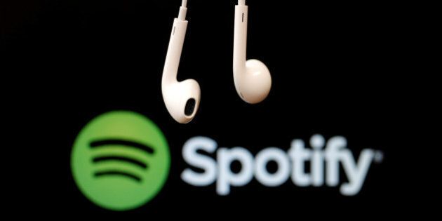 Headphones are seen in front of a logo of online music streaming service Spotify in this February 18, 2014 illustration picture. REUTERS/Christian Hartmann/File Photo