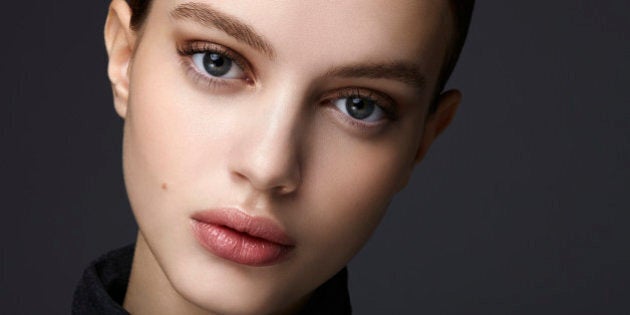 beautiful brunette studio shot in front of a dark background - nude make up-Professional make-up and hairstyle