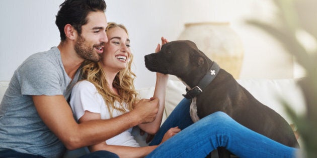 Shot of a young couple relaxing at home with their dog