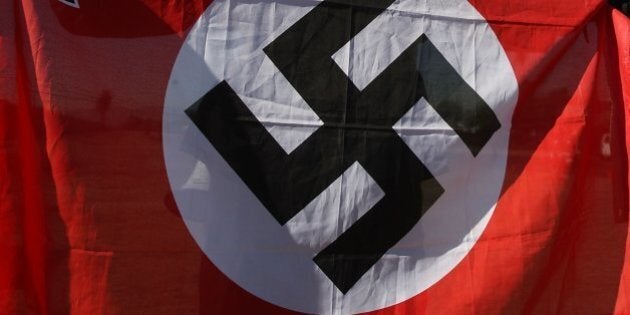 RIVERSIDE, CA - OCTOBER 24: Members of the white supremacist group, the National Socialist Movement, hold swastika flags at the NSMÕs anti-illegal immigration rally near a Home Depot store on October 24, 2009 in Riverside, California. It is the second such demonstration in Riverside by the Detroit-based Neo-Nazi group in the past month. The last rally was soon broken up by police after clashes with counter-protesters. (Photo by David McNew/Getty Images)