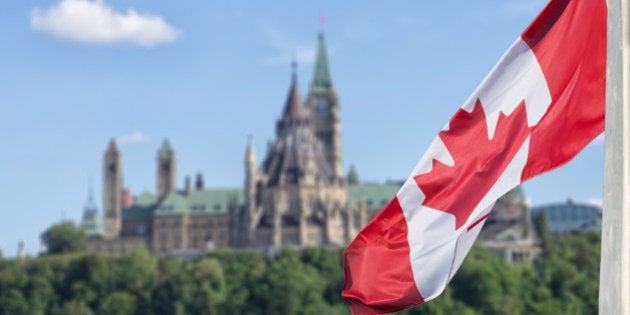 Canadian flag waving with Parliament Buildings hill and Library in the background