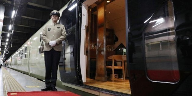 This picture taken on April 26, 2017 shows a crew member standing next to the Train Suite Shiki-Shima, operated by East Japan Railway, at Ueno Station in Tokyo during a press preview.The luxury sleeper Shiki-Shima, which can accommodate up to 34 passengers, has 10 cars, including a lounge car, a dining car and two observatory cars. The train has only 17 cabins, all suites, and the most expensive room, known as Shiki-Shima Suite, is priced at 950,000 yen (8480 USD) per person when shared by two people. / AFP PHOTO / JIJI PRESS / str / Japan OUT (Photo credit should read STR/AFP/Getty Images)