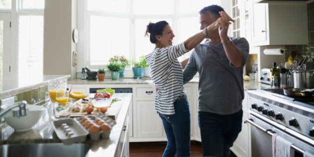 Playful couple dancing in kitchen