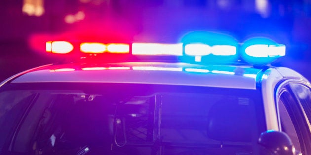 The roof of a police patrol car at night, with the blue and red lights flashing.