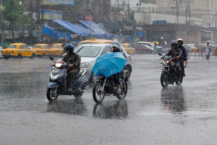 People ride their motorbikes during heavy rains in Kolkata, May 3, 2019. 