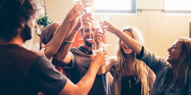 Friends partying in a bar. They are toasting with beer and champagne, dancing, drinking, and having fun.